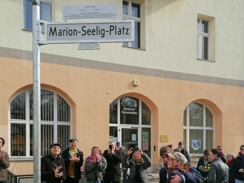 Freude nach der Enthüllung des Straßenschilds mit Erklärungstafel