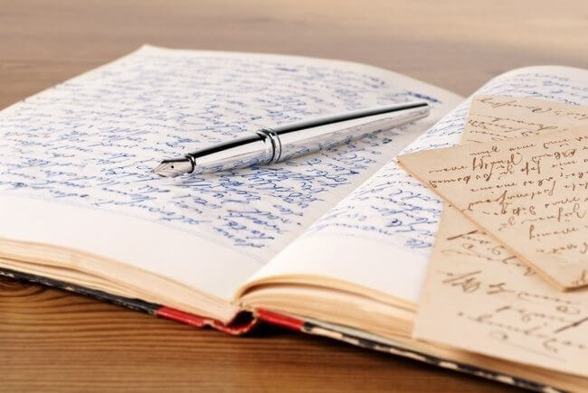Aufgeschlagenes dickes Schreibheft mit Stift
